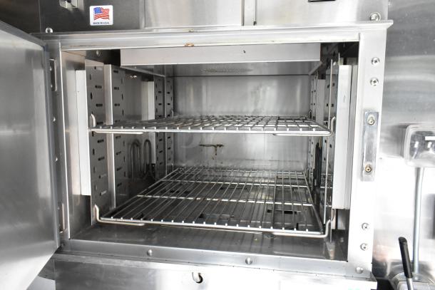 Stainless steel commercial food trailer appliance with empty racks, "Made in U.S.A." label visible. Excellent condition.