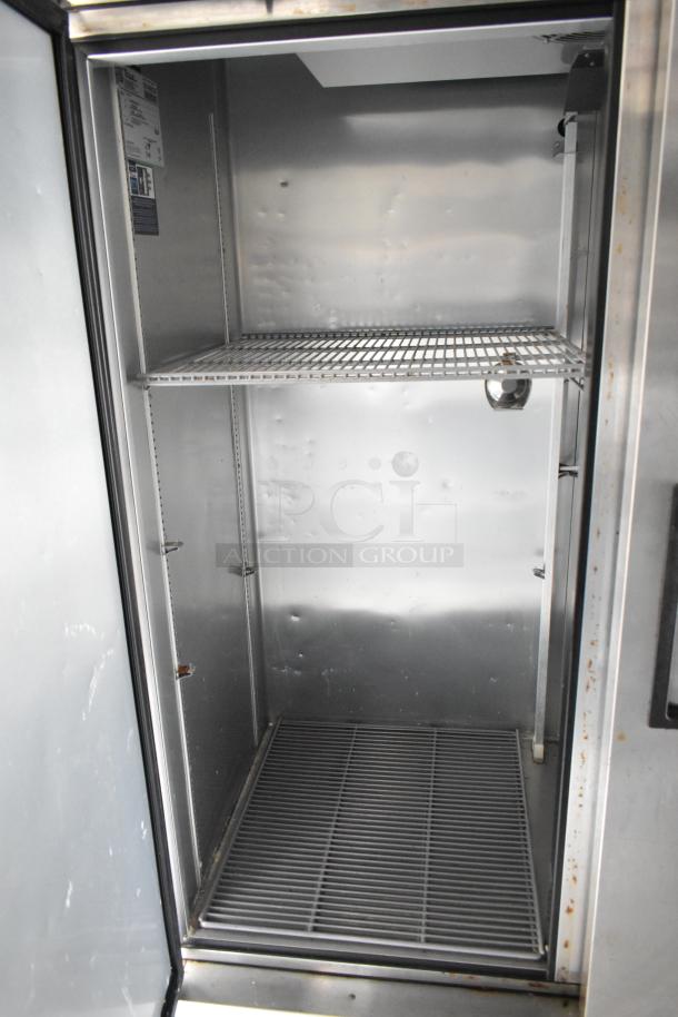 Stainless steel interior of a commercial refrigerator with wire shelving. Clean condition, suitable for a food trailer.