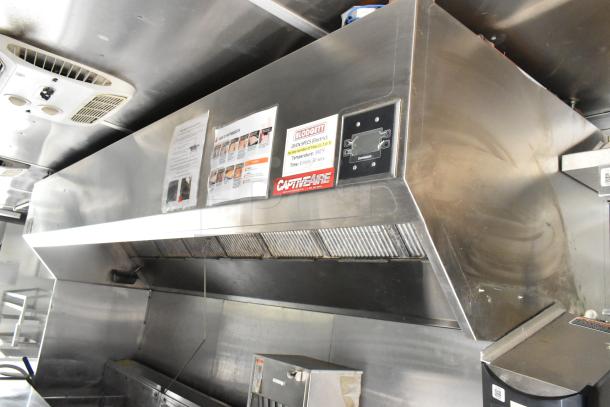 Fully outfitted food trailer interior with stainless steel CaptiveAire hood. Includes Blodgett oven specs label. Ready for use.