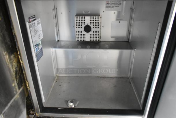 Interior view of a food trailer refrigerator, showing stainless steel shelves and ventilation. Labels detail appliance specs.