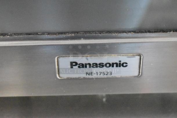 Close-up of a Panasonic NE-17523 label on stainless steel appliance, part of a fully outfitted food trailer.