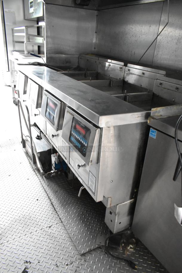 Fully outfitted food trailer kitchen with stainless steel appliances and fixtures, ready for opening day.