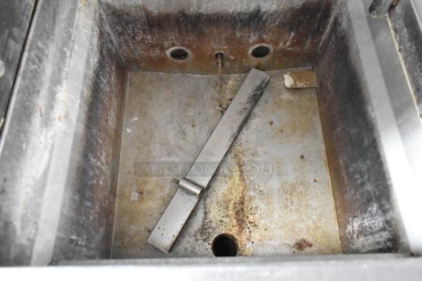 Rusted metal food trailer sink with drain and attached metal fixture, showing wear. Ready for refurbishing.