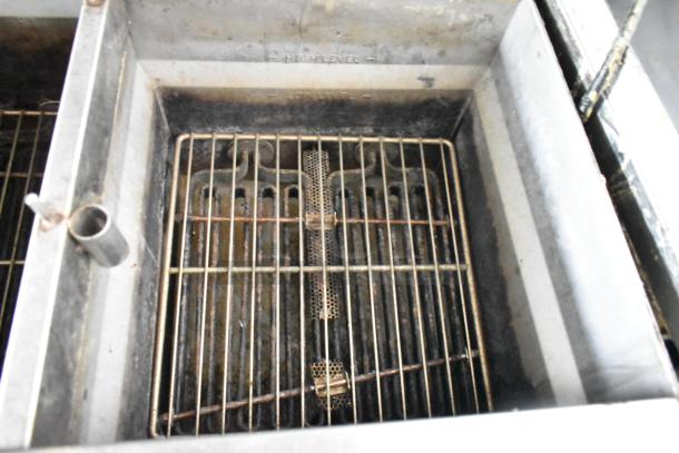 Antique stainless steel commercial fryer in fair condition, with visible high and low levels etched inside.