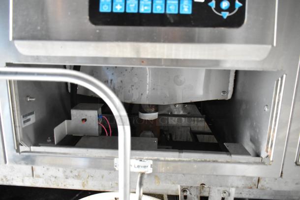 Food trailer interior showing stainless steel appliance with control panel and lever, indicating readiness for use.