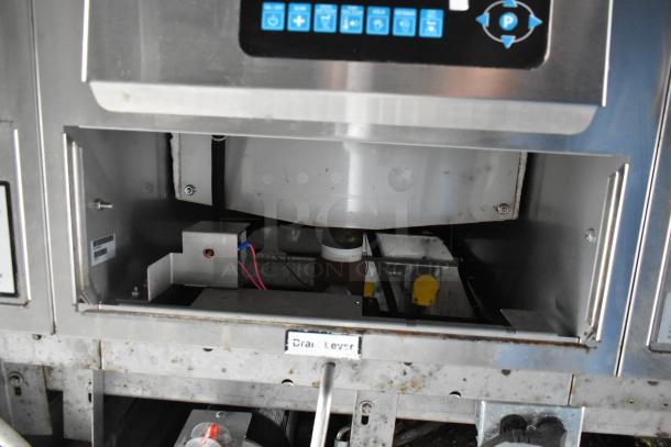 Food trailer appliance interior, showing stainless steel construction and control panel with labeled buttons; visible drain lever and wiring.