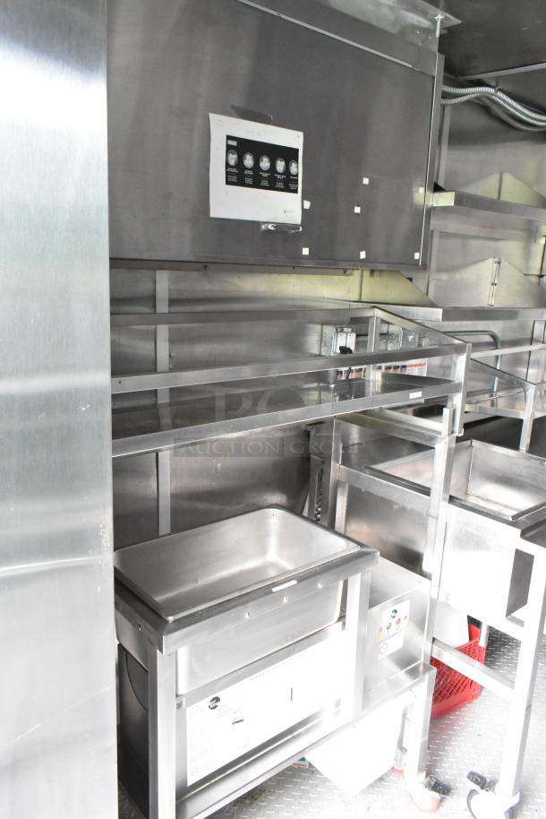 Fully outfitted food trailer interior with stainless steel counters and sinks. Includes control panel, ready for use.