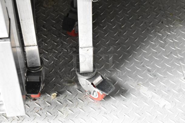 Food trailer interior showing durable steel flooring and locking caster wheels, highlighting mobility and robust build.