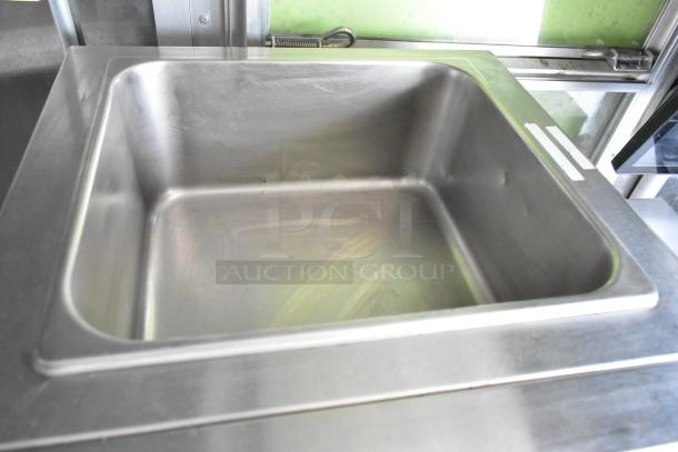 Stainless steel sink in a fully outfitted food trailer, suitable for commercial use. Clean and ready for operation.