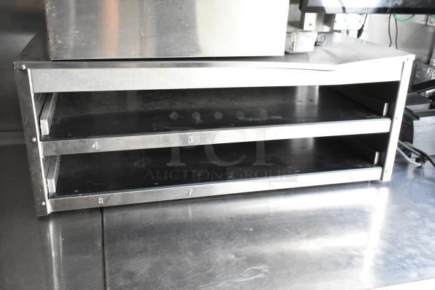 Stainless steel food trailer appliance with numbered, adjustable shelving. Clean and ready for use.
