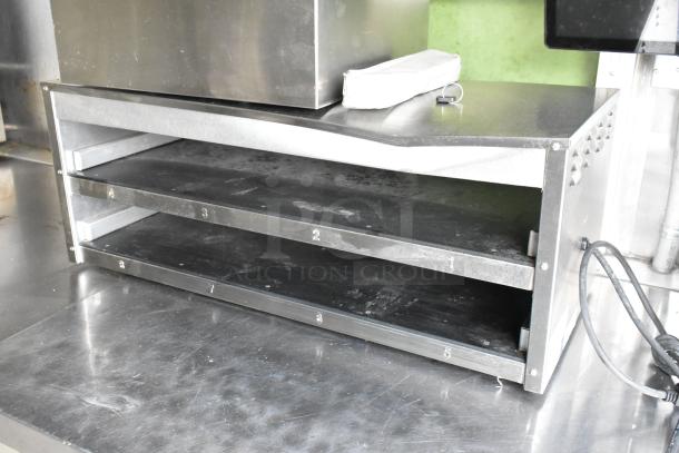 Stainless steel shelving unit inside a food trailer, featuring numbered shelves, in good condition.