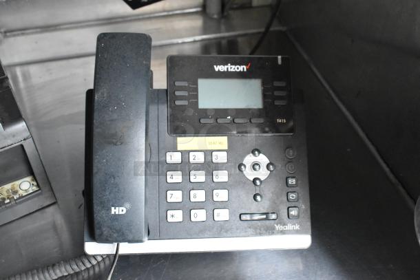 Verizon Yealink T41S phone on a metal surface, displaying HD logo, numeric keypad, and navigation buttons.
