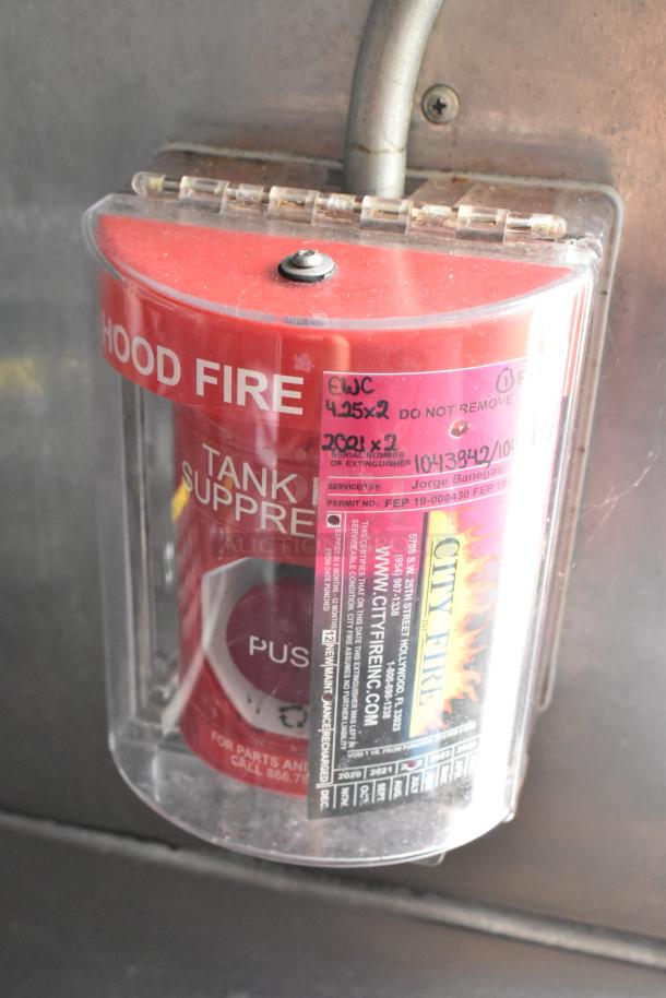 Fire suppression system in food trailer, showing "Hood Fire" label and inspection details. Good condition.