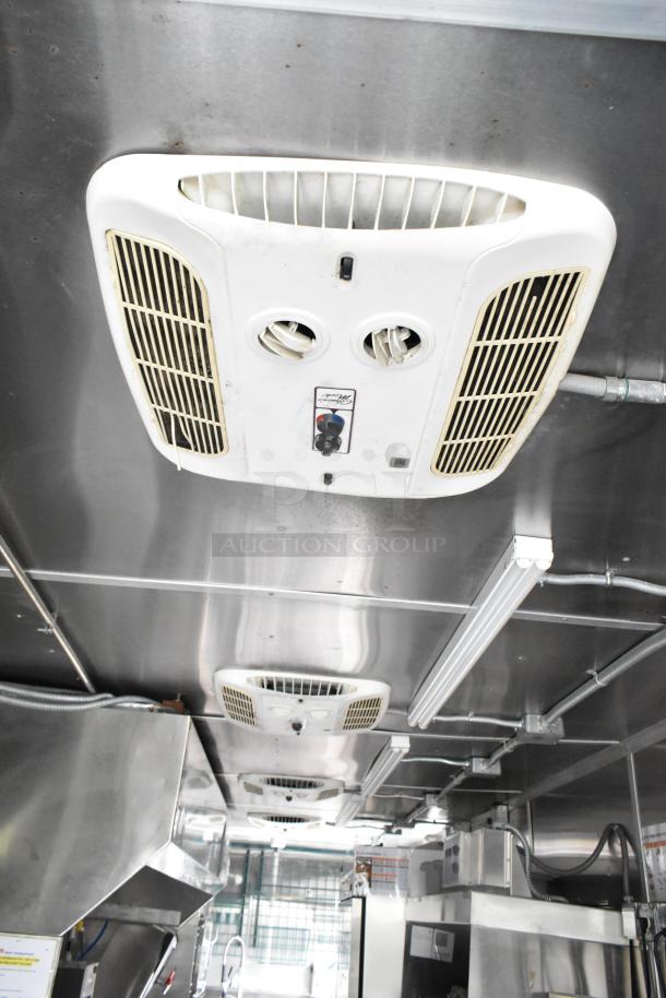 Fully outfitted food trailer interior with stainless steel appliances and ceiling vents, ready for opening day.
