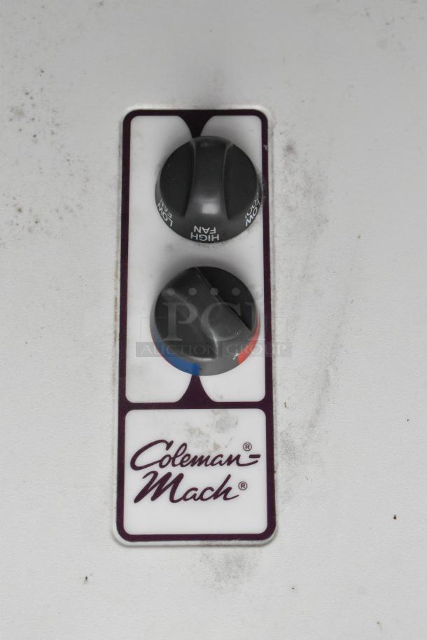 Coleman Mach control panel on white surface, featuring high/low fan settings. Slight wear visible.