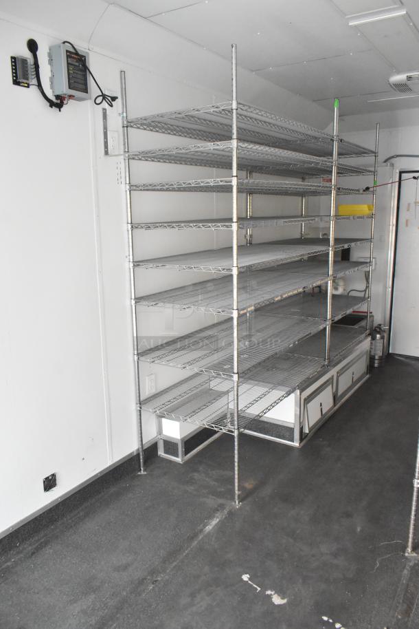 SDG Trailers trailer interior with metal shelving units, electrical box, and fixtures. Clean and well-maintained condition.