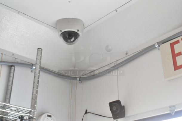 Interior of SDG trailer with security camera, exit sign, and wiring visible in the corner.