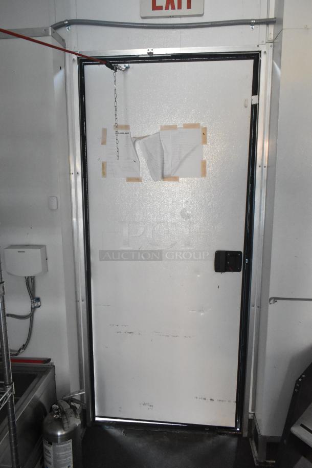 SDG Trailers Trailer with white exit door, chain lock, and exit sign. Visible wear and some taped papers on door.