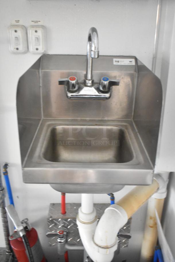 Stainless steel sink with a dual-handle faucet, part of SDG Trailers setup, features water and wash police operation labels.