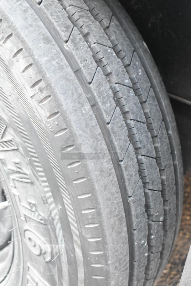 Close-up of a SDG Trailers tire showing tread pattern and condition. Visible brand markings and tread wear details.