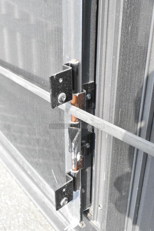 Close-up of SDG Trailers trailer door hinge and latch, showing sturdy black metal construction and secure fasteners.