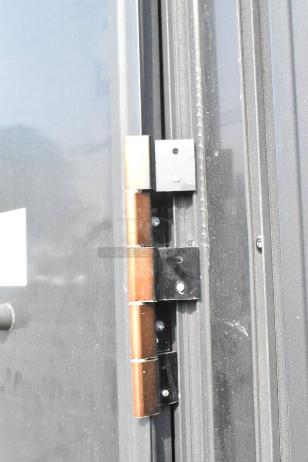 Close-up of a hinge on an SDG Trailers trailer, showing metal construction and attached to a dark-colored doorframe.