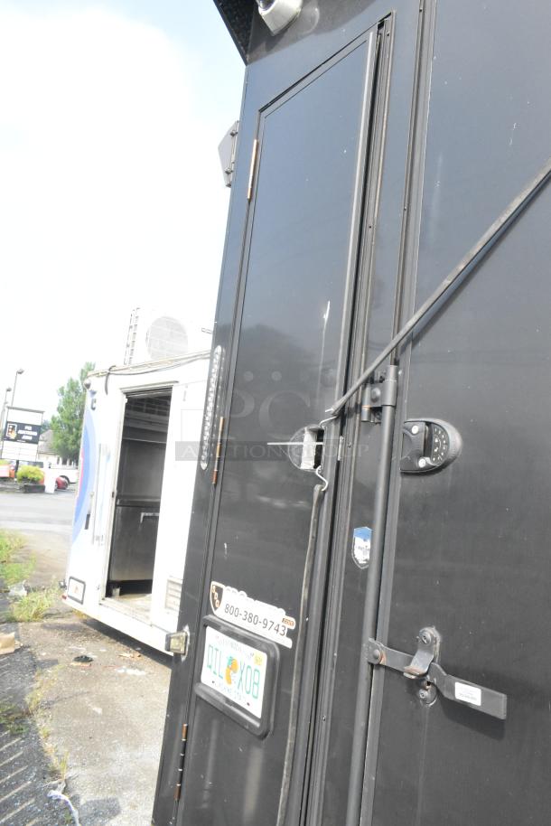 Black SDG Trailers trailer showing entry door, lock handle, and visible Florida license plate. Good condition.