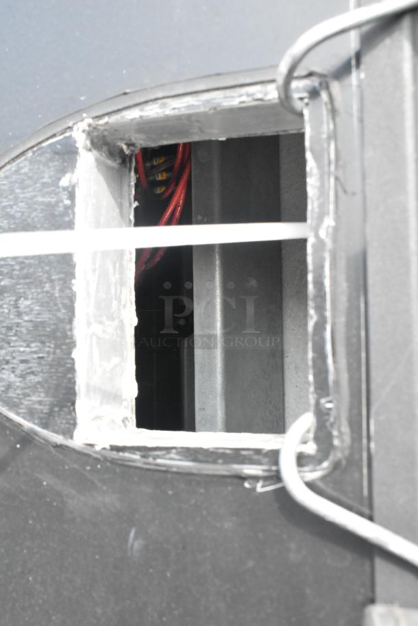 SDG Trailers trailer detail showing interior wiring through an open panel. Exterior is dark with visible metal framing.