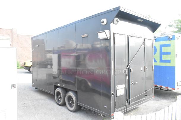 Black SDG Trailers trailer with dual axles. Features security lights, lockable doors, and sturdy construction. Good condition.