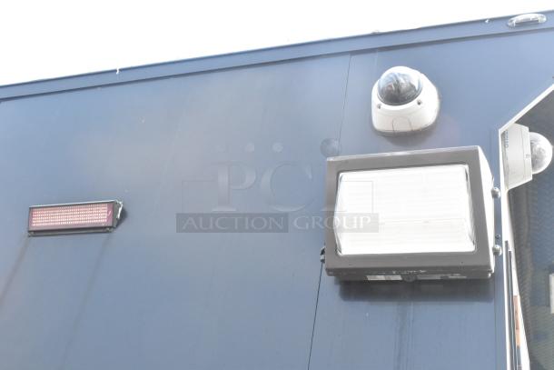 SDG Trailers trailer section with surveillance camera and floodlight, highlighting the security features and exterior condition.