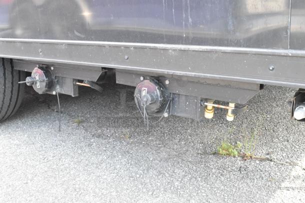 SDG Trailers trailer underside, showcasing brake components. Visible wear on black metal structure. Road-ready condition.