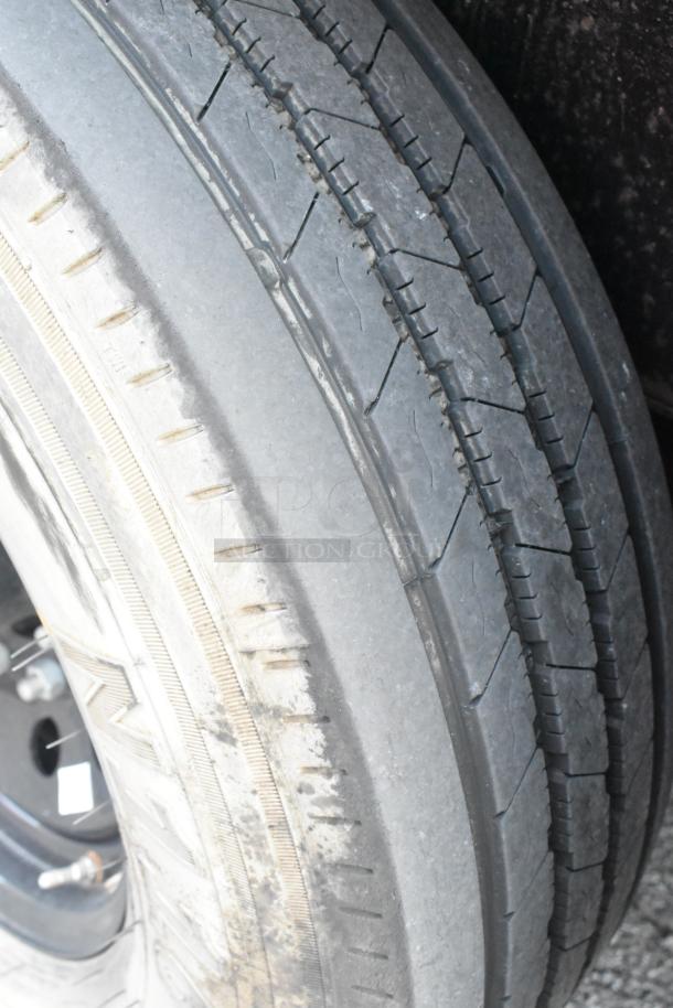 Close-up of a worn tire on an SDG Trailers trailer. Visible signs of tread wear and aging, typical for used condition.