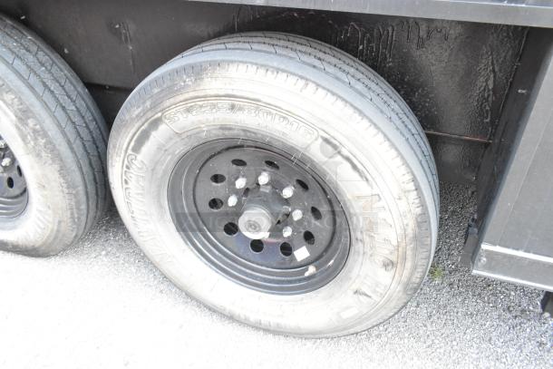 SDG Trailers tire close-up; features Carlisle Radial Trail HD tire, size ST235/80R16. Black steel rim, good condition.