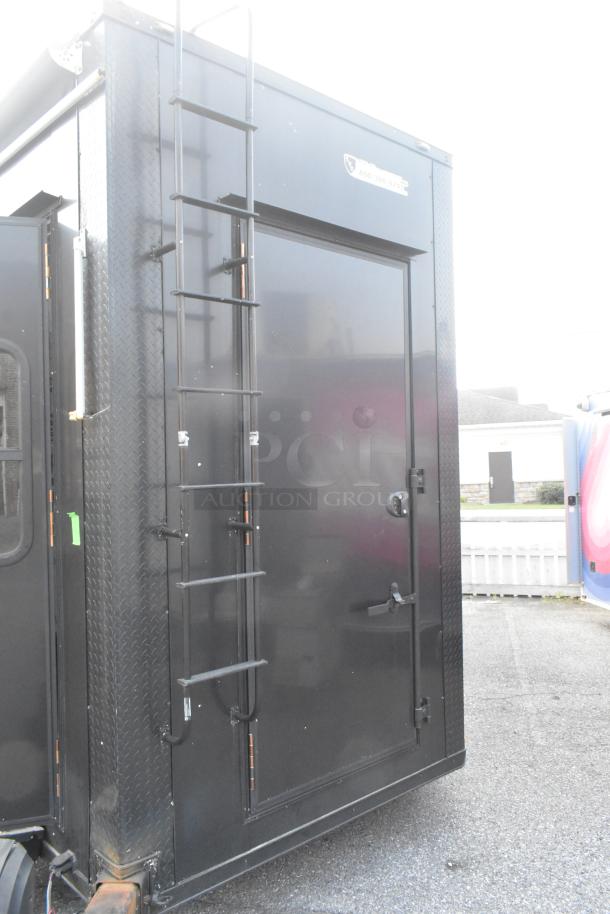 SDG Trailers utility trailer with a black metal exterior, ladder, and secure door. Durable design for appliance or fixture transport.