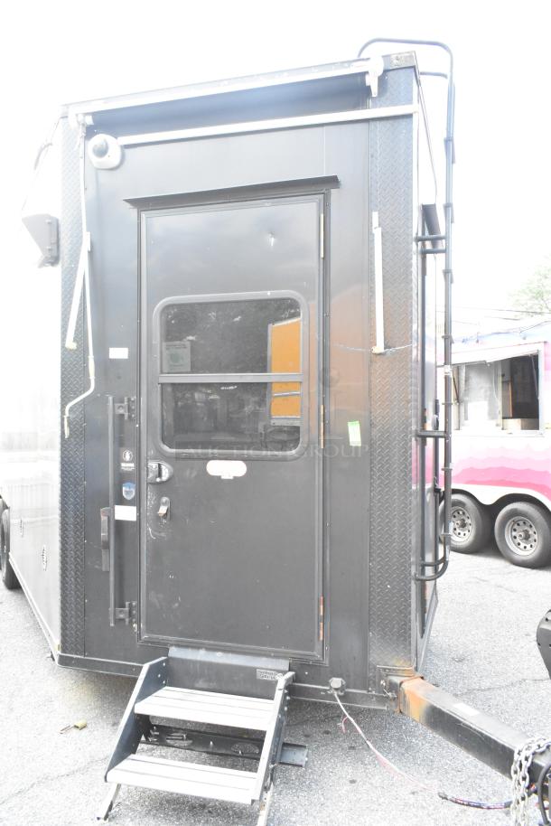 Black SDG Trailers trailer with side door, step ladder, and exterior ladder. Visible wear, potential fixtures unseen.