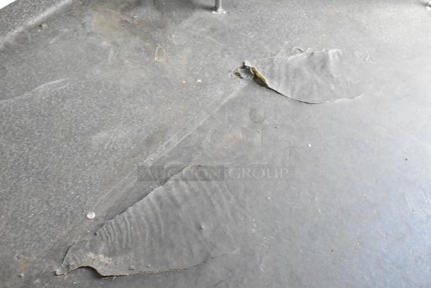 Damaged surface of an SDG Trailers trailer. Image shows peeling and scratches on a dark, flat surface.