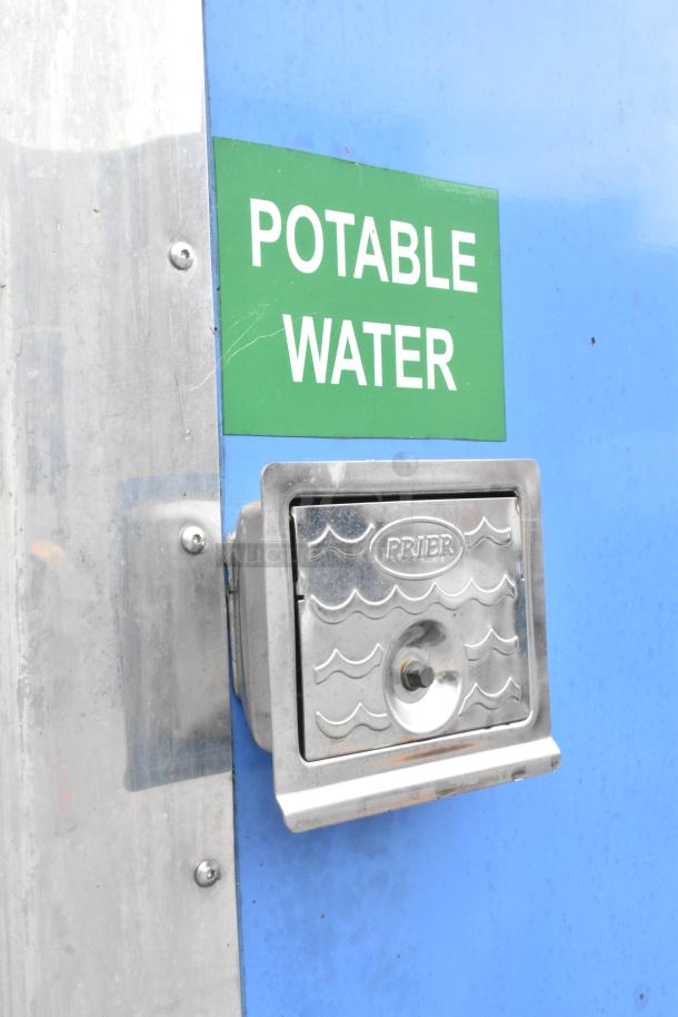 Potable water connection on a blue food trailer, featuring a Prier valve and a green label indicating potable water access.
