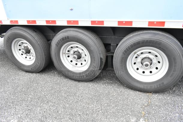 Three-wheel section of fully outfitted reef food trailer, featuring Dutymax and Freedom Hauler tires on an asphalt surface.