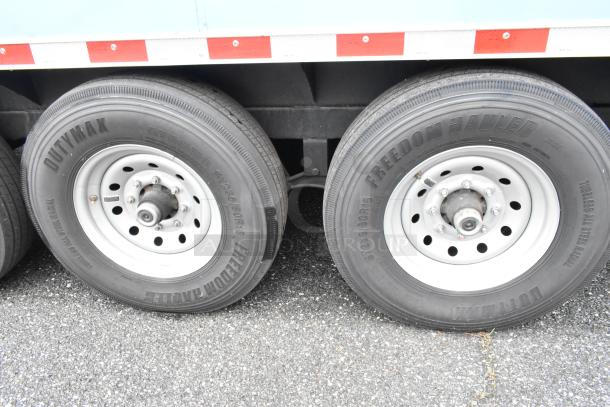 Two Dutymax and Freedom Hauler tires with steel rims on a food trailer. The tires show clear branding and tread detail.