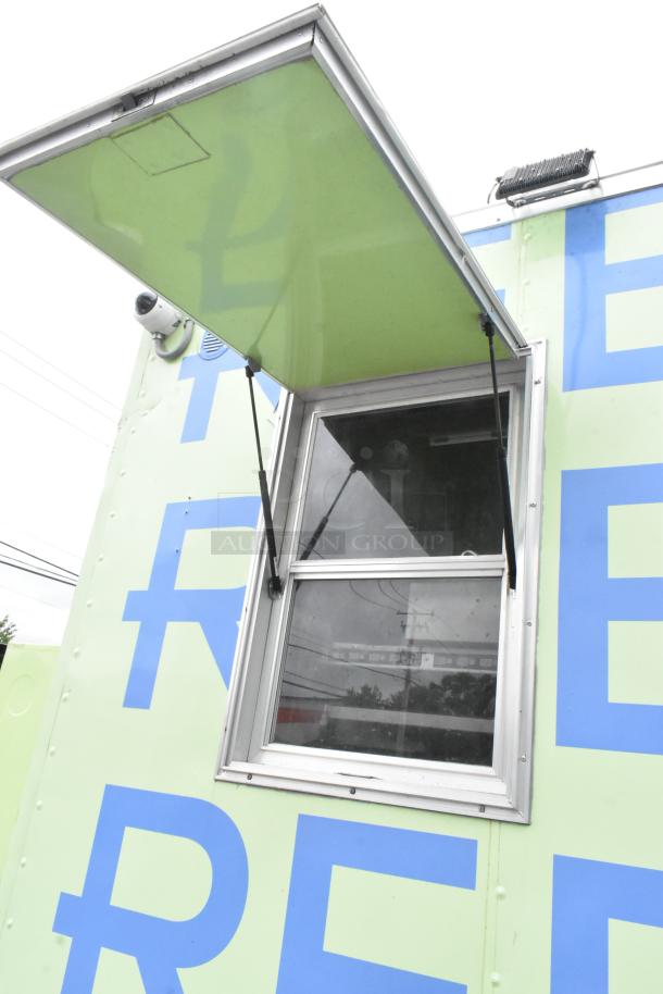 Fully outfitted Reef food trailer with serving window, green and blue exterior, ready for use. Includes camera for security.