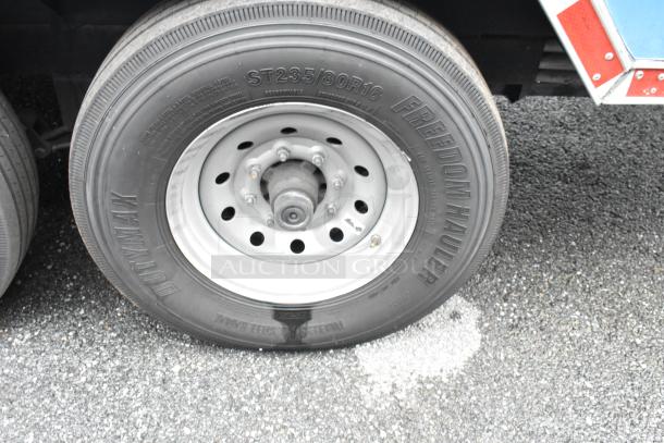 Close-up of a Freedom Hauler tire on a food trailer, showing the ST235/80R16 size and Dutymax branding.