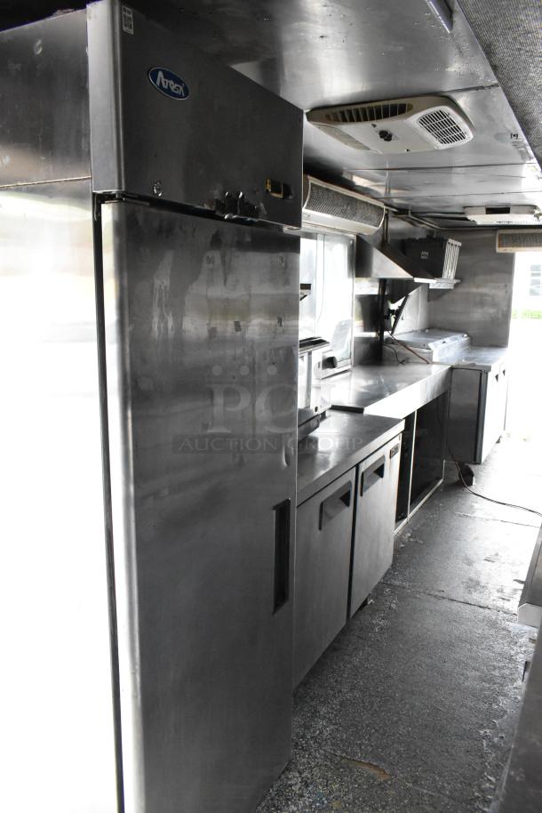 Fully equipped food trailer interior, stainless steel appliances including an Arctic Air fridge, ready for operation.