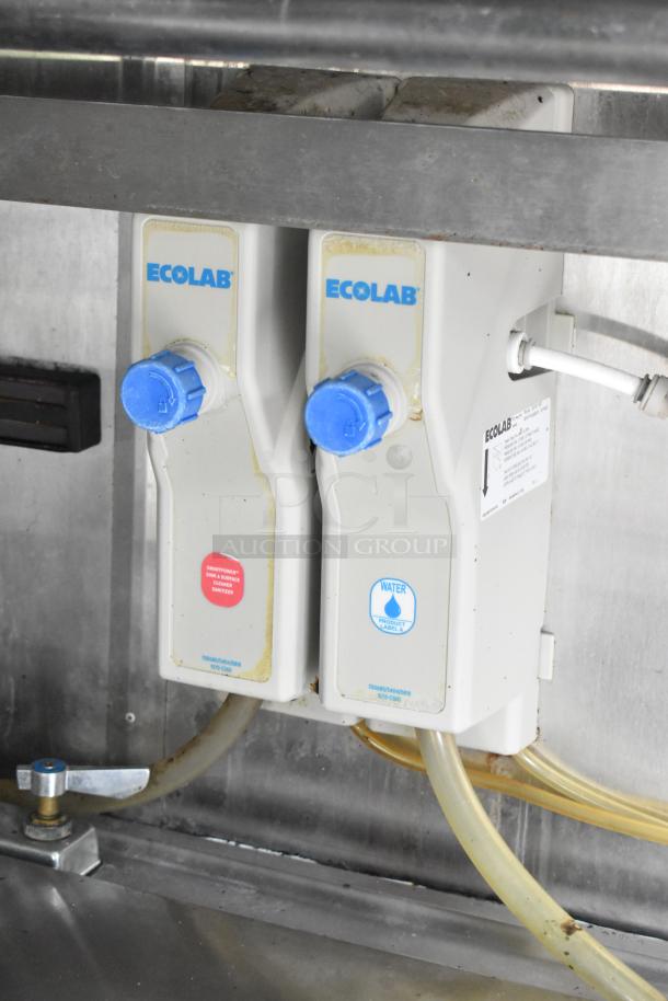 Ecolab dispenser system with two units, featuring sanitizer and water labels, in a food trailer setup.