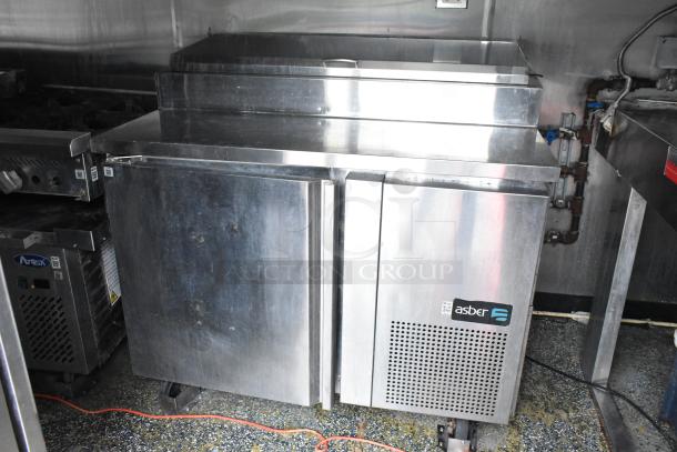 Stainless steel Asber refrigerator in a fully equipped food trailer, featuring durable construction and modern design.