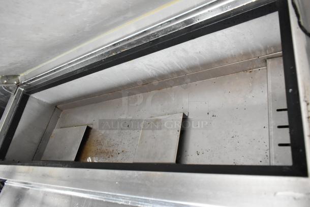 Interior of a food trailer with stainless steel surfaces, showing a clean, spacious area for equipment placement.