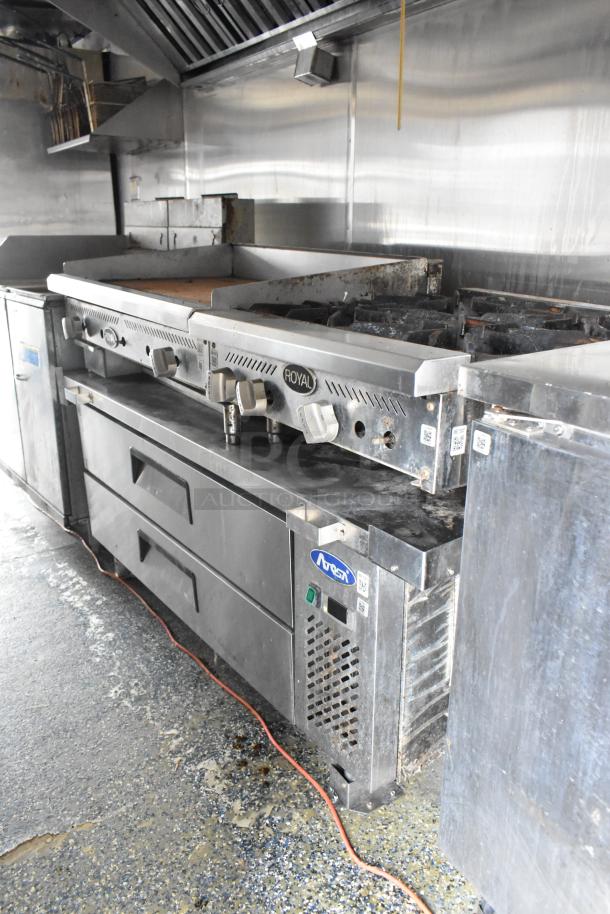 Fully outfitted food trailer kitchen with Royal commercial stove, grill, fryers, and NSF refrigeration. Ready for service.