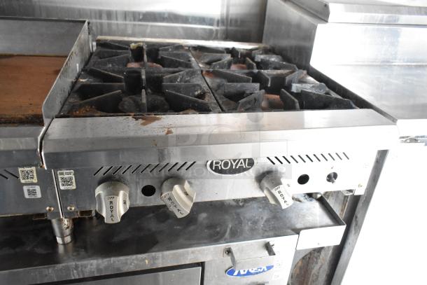 Royal stove in a food trailer, featuring multiple burners and dials. Slight wear visible. Essential for kitchen operations.