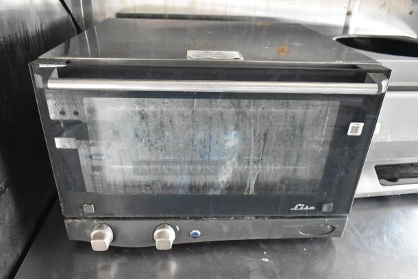 Commercial-grade oven in used condition, featuring two control knobs and a glass door, branded "Lisa".