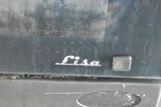 Close-up of a "Lisa" branded panel or appliance in the food trailer, slightly worn surface, likely part of the trailer's equipment.
