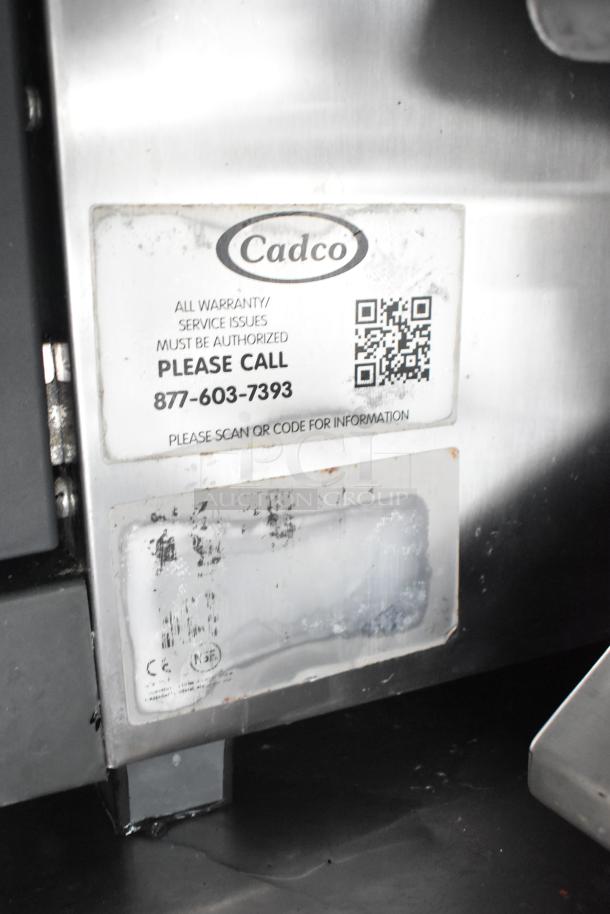 Cadco appliance label inside food trailer, includes QR code for service info and contact number.